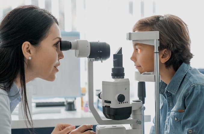 A little boy has his eyes examined by a pediatric optometrist.