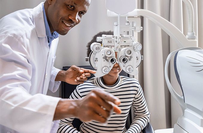 woman getting an eye exam where doctor uses phoropter