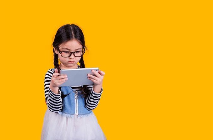 young girl wearing eyeglasses looking at her mobile phone