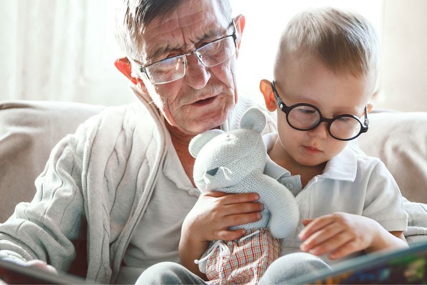 grandfather reading a book to his grandson
