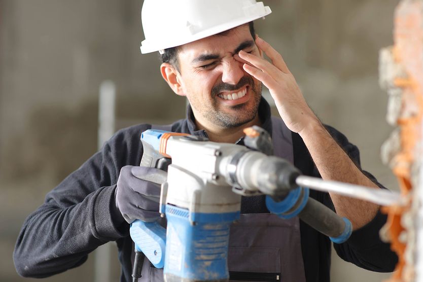 Construction worker with an eye injury Construction worker experiencing an eye injury while using a power drill.