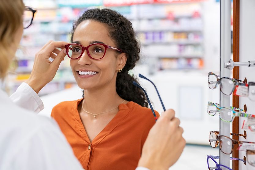 woman trying on eyeglasses to treat her astigmatism