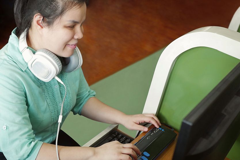 Guide for Visually Impaired College Students woman who is legally blind on the computer