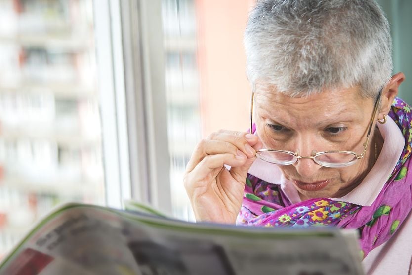 Adapting to an easy lifestyle for seniors with impaired vision senior woman with low vision having difficulty reading