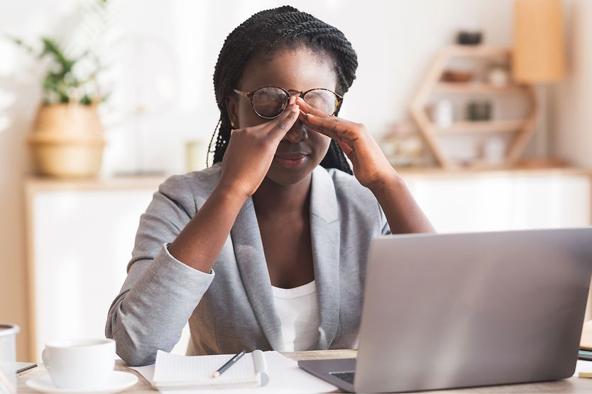 Has WFH changed the way we see? Woman rubs eyes while working on computer