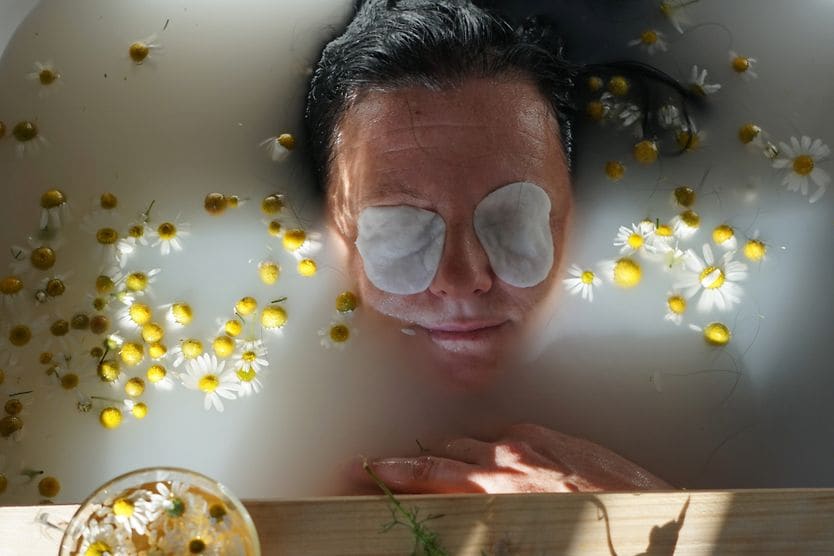 How to reduce eye floaters naturally woman relaxing in a tub with compress over her eyes to naturally treat her eye floaters