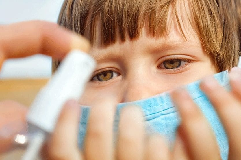 What to do if you get hand sanitizer in your eye closeup of child's eyes looking at hand sanitizer being dispensed in his hands