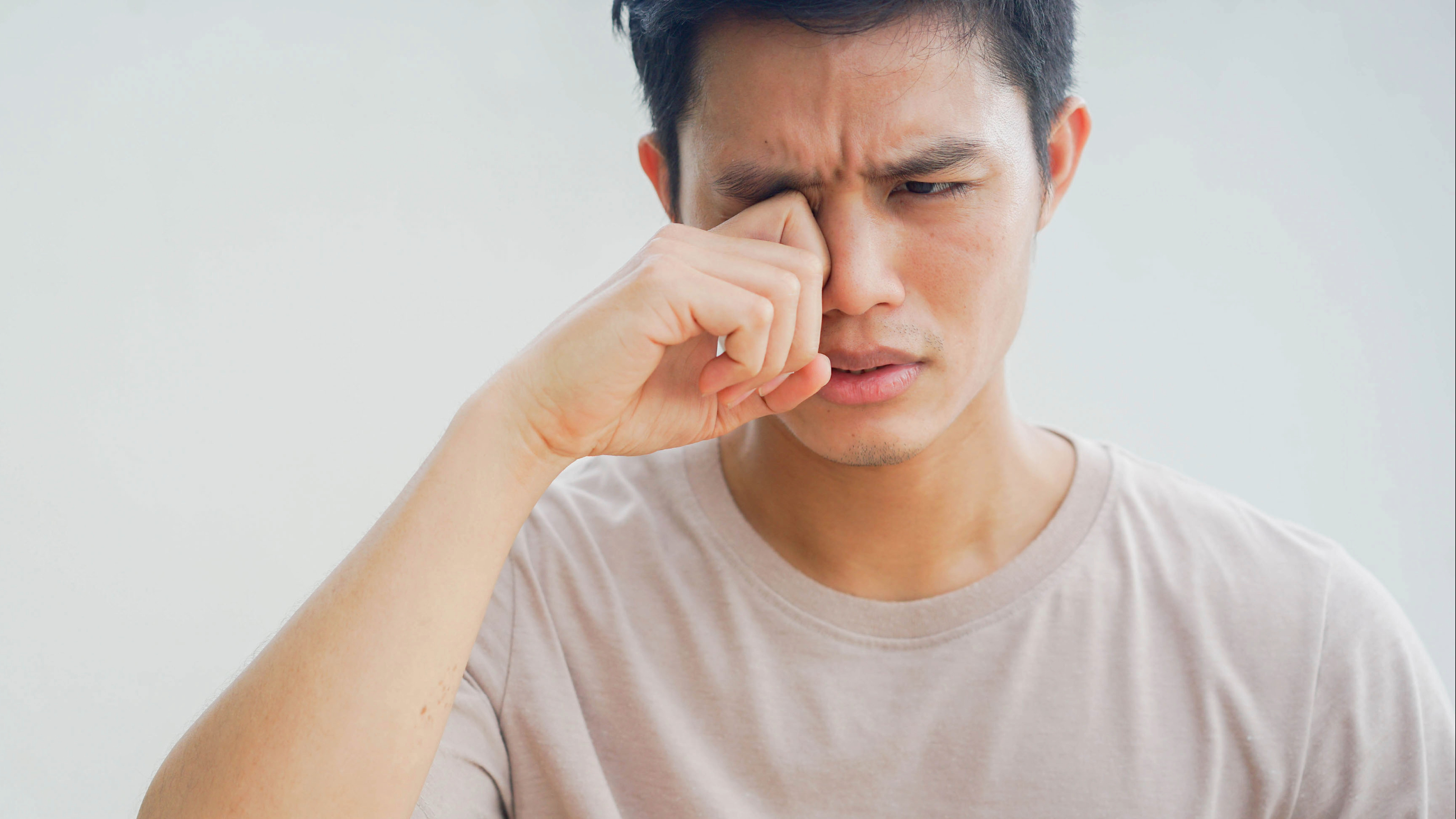 man rubbing eye due to giant papillary conjunctivitis