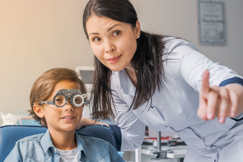 A young boy wearing glasses gets help with his homework