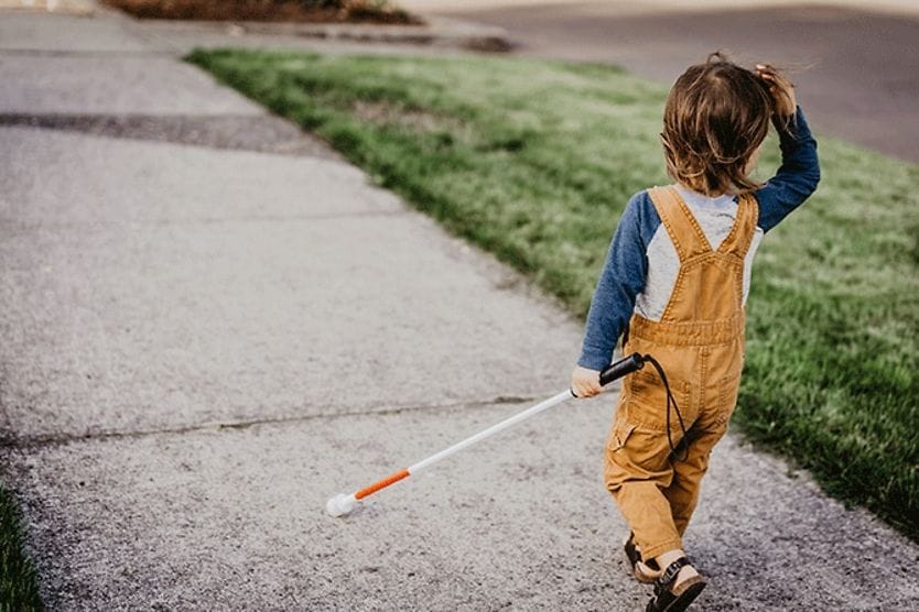 child with high myopia using walking stick who has a rare condition