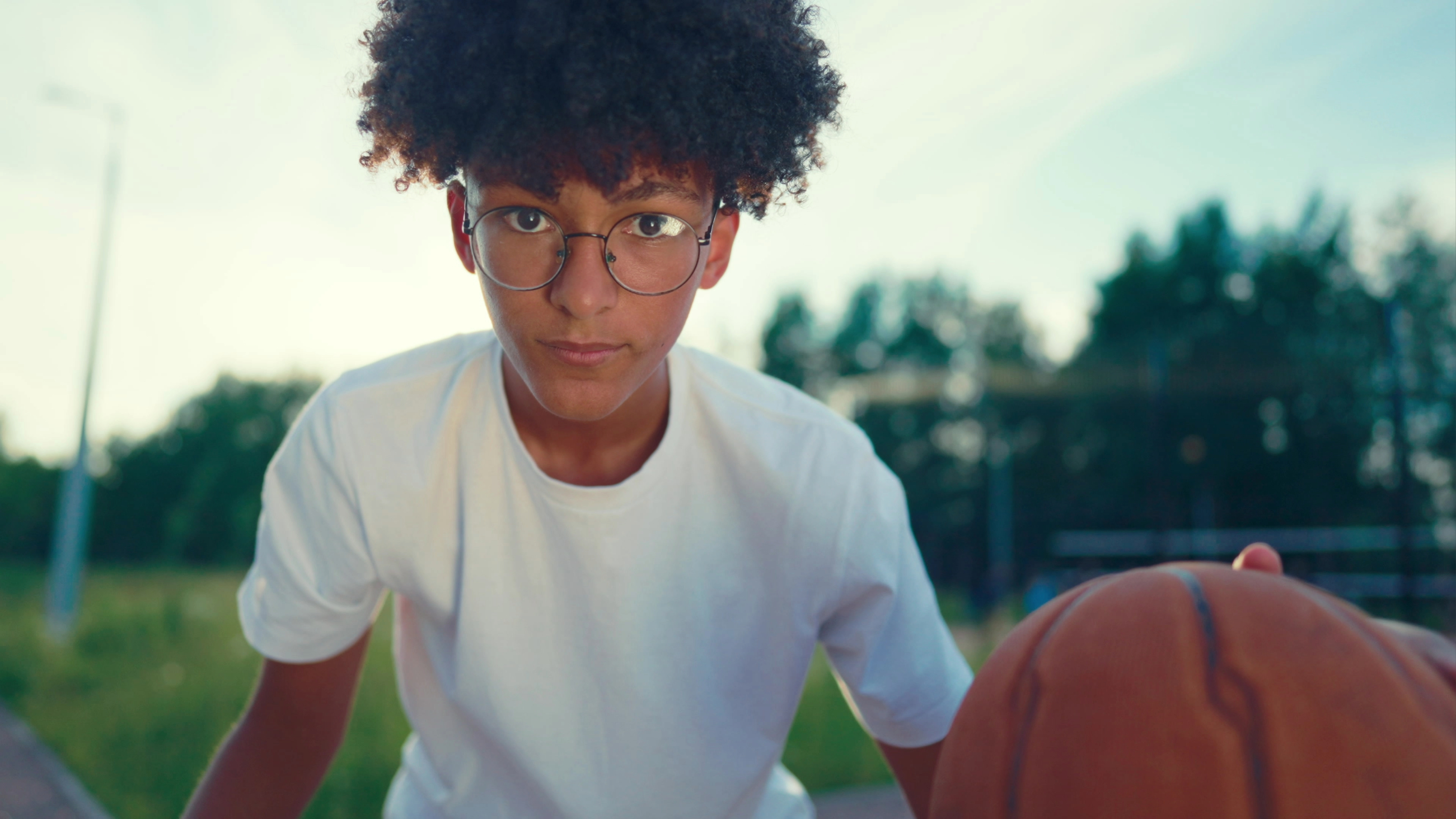 teen with myopia wearing glasses and playing basketball