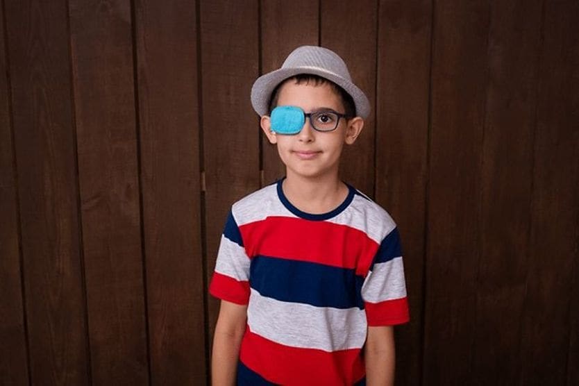 Nystagmus vs. strabismus young boy wearing an eye patch with nystagmus or strabismus