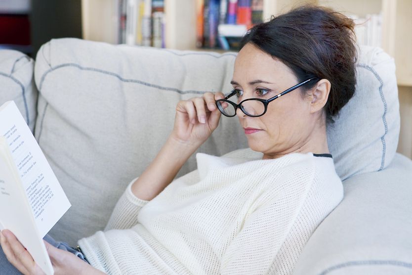 Presbyopia: What causes it and how to treat it Woman with eyeglasses reading a book