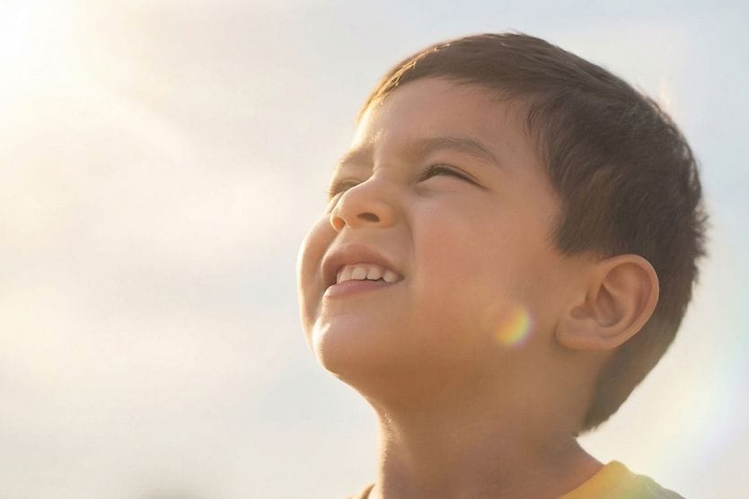 Child looking at the sun and getting ready to sneeze.