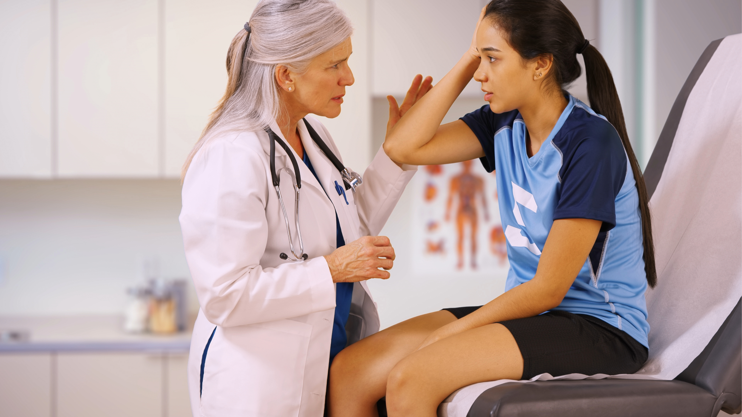 girl with a head injury getting eyes checked by a doctor