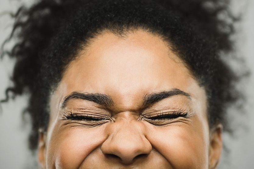 Excessive Blinking in Children and Adults Person smiling and half blinking.