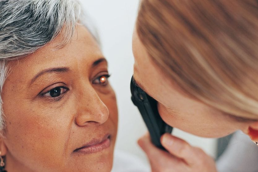 Eye doctor checking woman's eyes