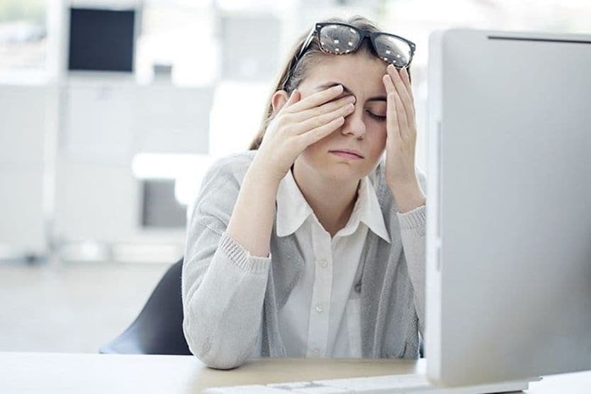 Tired eyes: How to deal with eye fatigue woman at a computer rubbing tired eyes