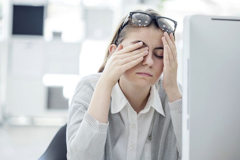 Tired eyes: How to deal with eye fatigue woman at a computer rubbing tired eyes