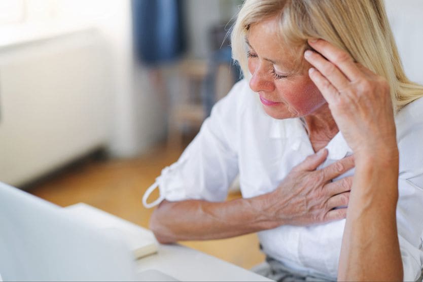 Is eye twitching a sign of a stroke? woman with eye twitching wondering if it's a sign of a stroke touching her temple and chest