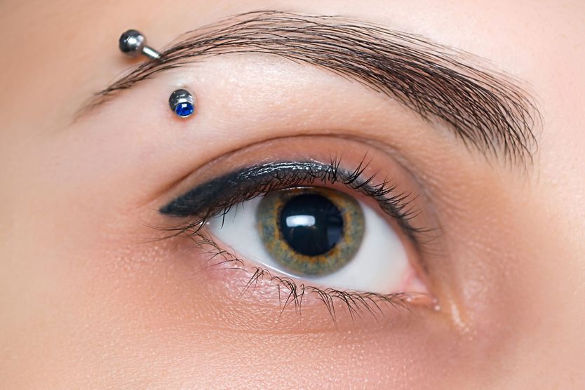 Eyebrow piercing: Complications and prevention Young woman with barbell eyebrow piercing.