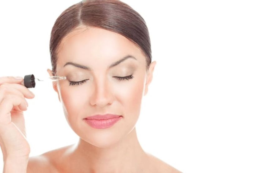 Woman using eyelash serum
