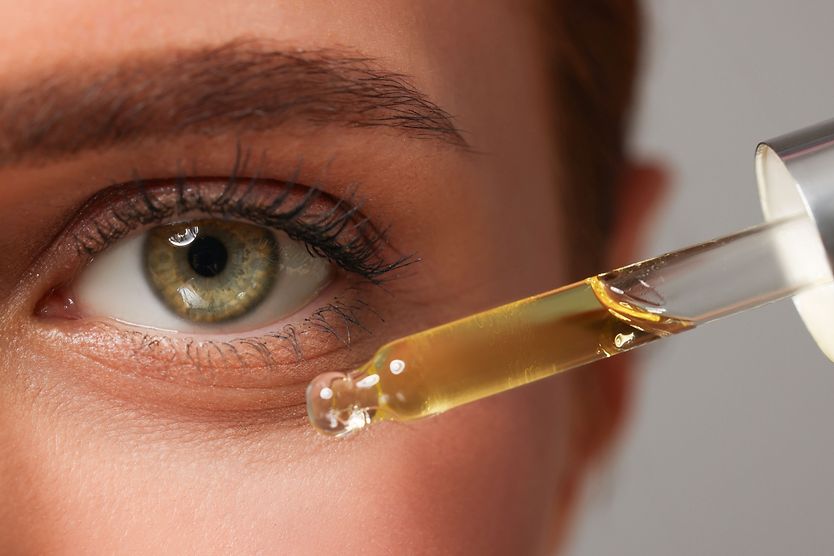 Is face oil safe to use around the eyes? woman putting on face oil near her eyes