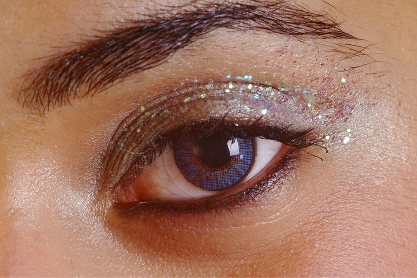 Is glitter makeup harmful to eyes? closeup of woman's eye with glitter makeup
