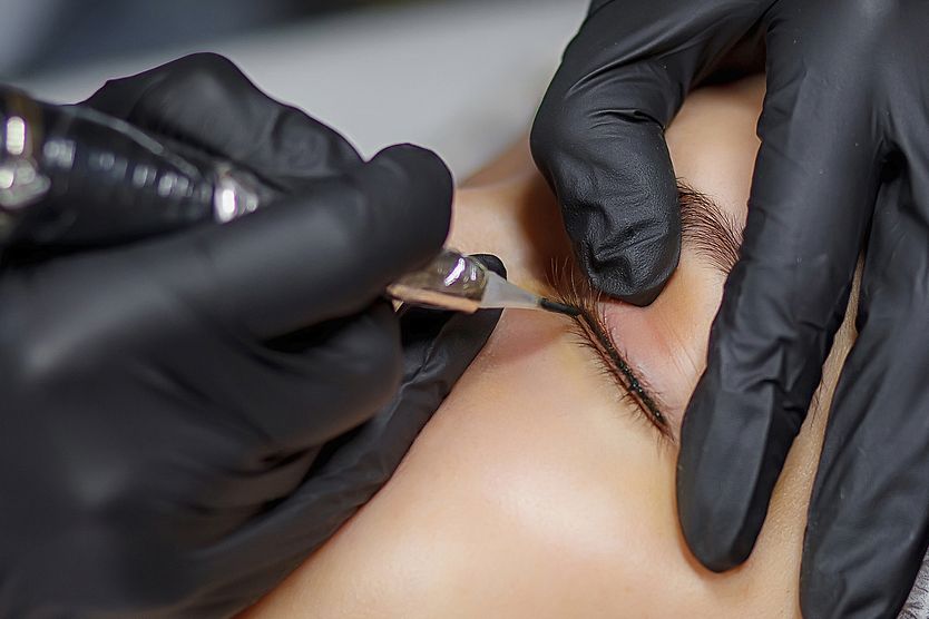 Permanent eyeliner: Pros and cons of cosmetic tattoos closeup of an eye getting a permanent eyeliner tattoo