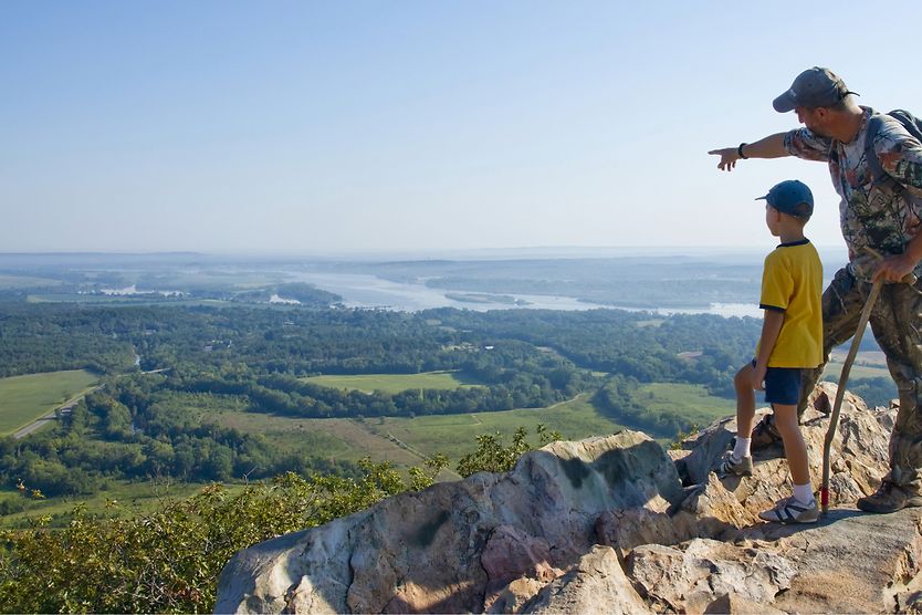 How far can the human eye see? father pointing to horizon with son on top of a mountain