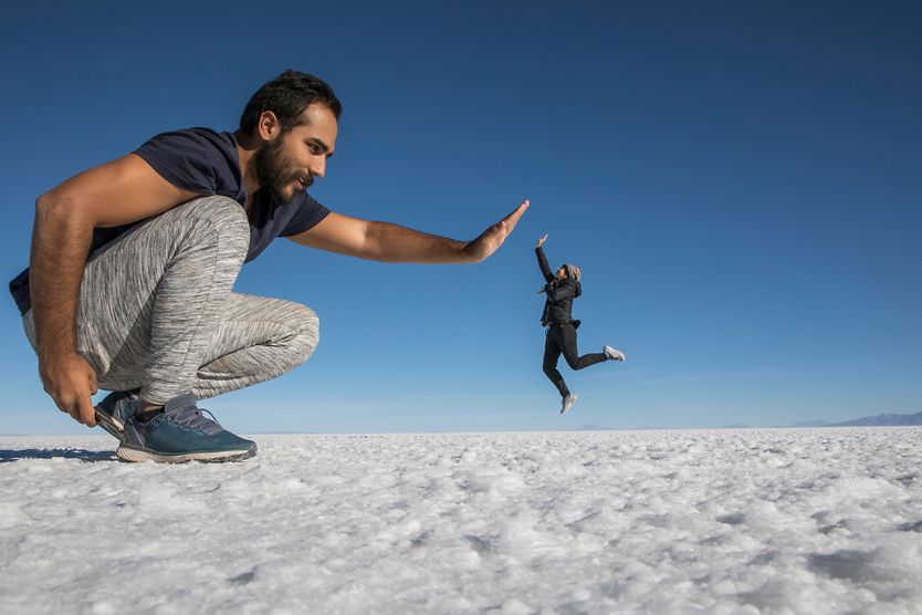 Optical illusions and the human eye Optical illusion of giant man and small woman high-fiving.