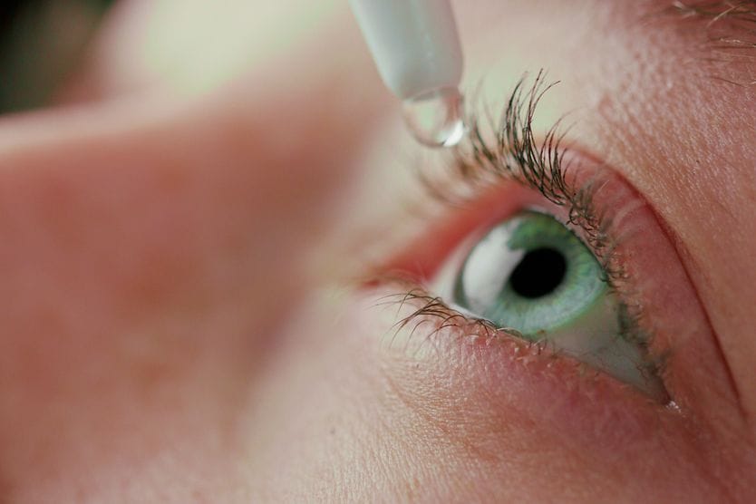 eye drops closeup of an eye getting treated with eye drops