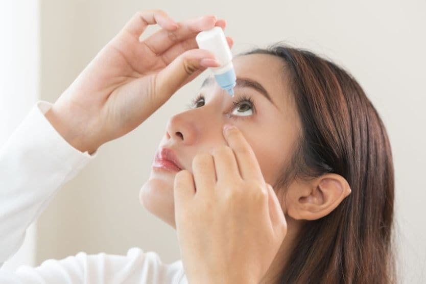 woman putting in eye drops