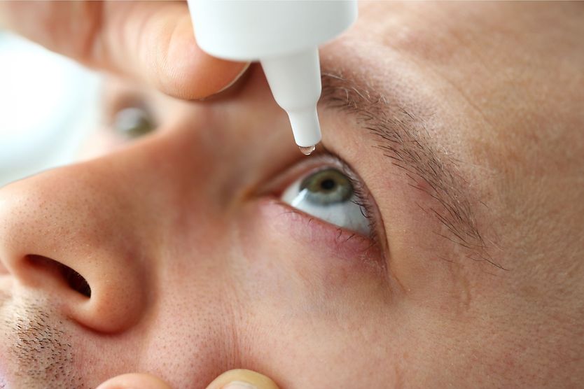 Man putting in eye drops
