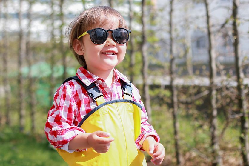 Are baby sunglasses necessary? Smiling child wearing sunglasses