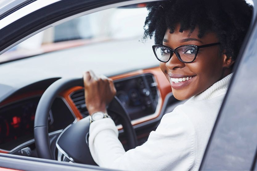 Road Safety: Why Healthy Vision Is So Important Person smiling while in a car.