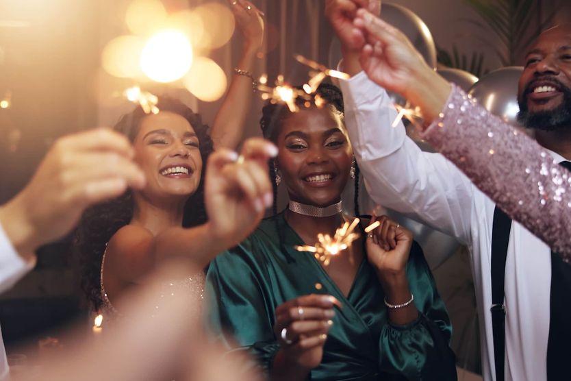 Group of people holding sparklers at a party