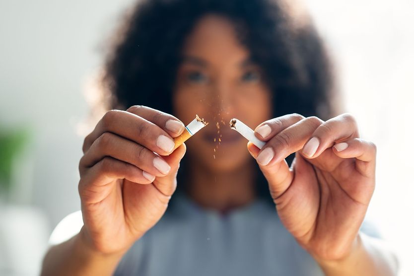 Person breaking cigarette in half.