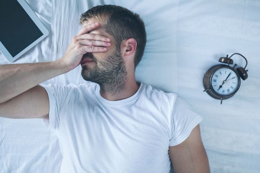 The harmful effects of sleep deprivation man with sleep deprivation holding his hand over his eyes