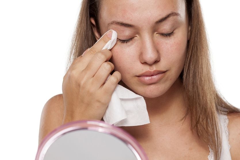 What can you use to clean your eyelids? woman using eyelid wipes to clean her eyelids
