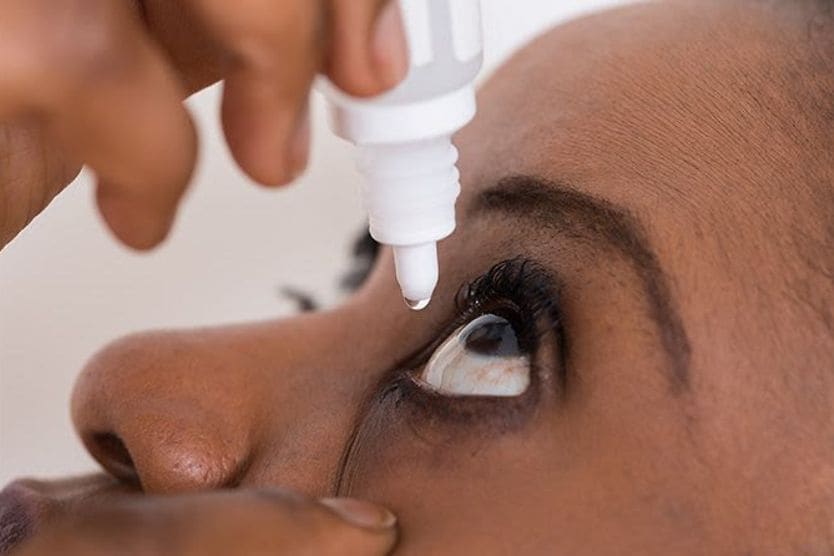How to whiten your eyes woman using eye drops to help whiten her eyes