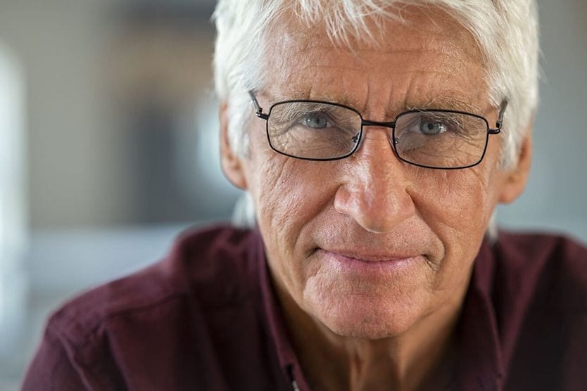 How vision changes as you age senior woman wearing glasses reading the newspaper