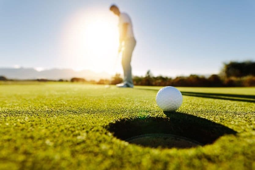 Sports vision skills you can practice at home A man wearing sunglasses plays golf.