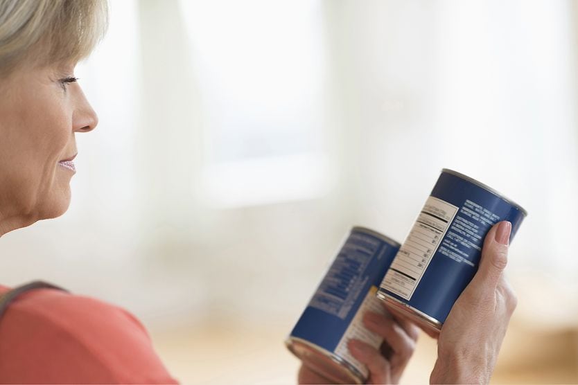 Treating presbyopia with monovision using contact lenses middle-age woman reading can labels without glasses