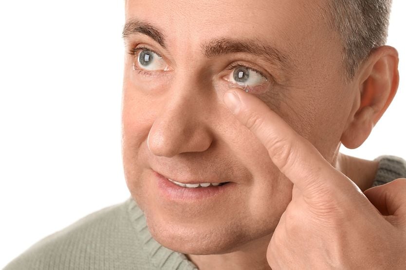 middle-age man putting in a contact lens