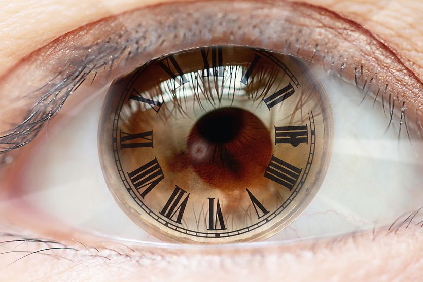 How long can I wear my contacts each day? closeup of eye with roman numerals clock.