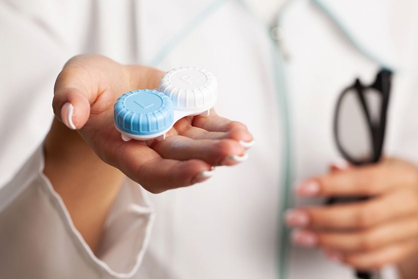 Understanding your contact lens prescription Woman holds out contact lens case in hand
