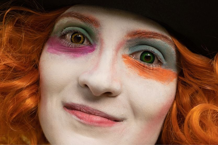 red-headed woman with costume makeup and colorful cosplay contact lenses