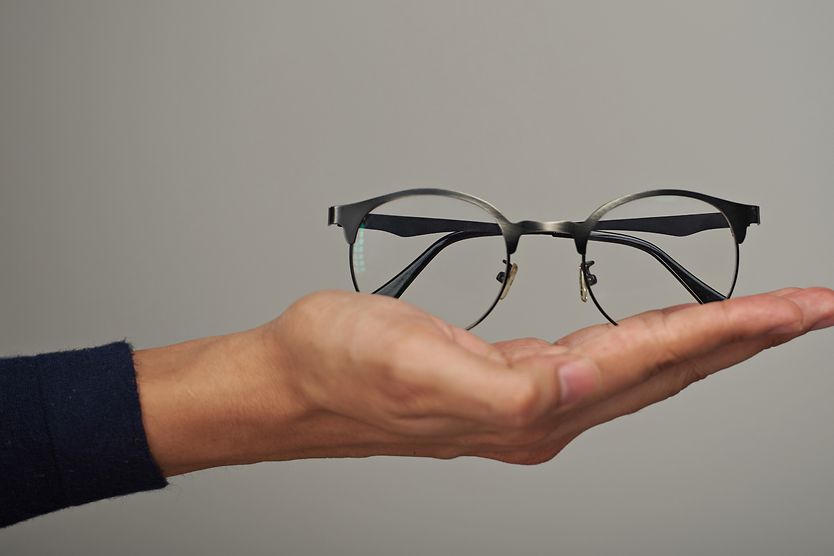 hand holding a pair of eyeglasses ready to donate
