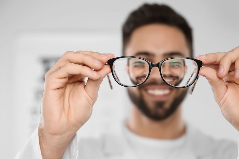 eye doctor holding up a pair of eyeglasses